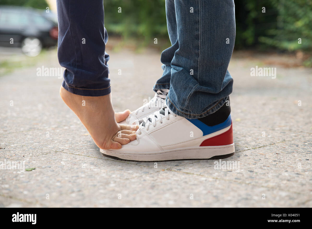 Close-up Of Kissing Couple Feet's On Street Stock Photo