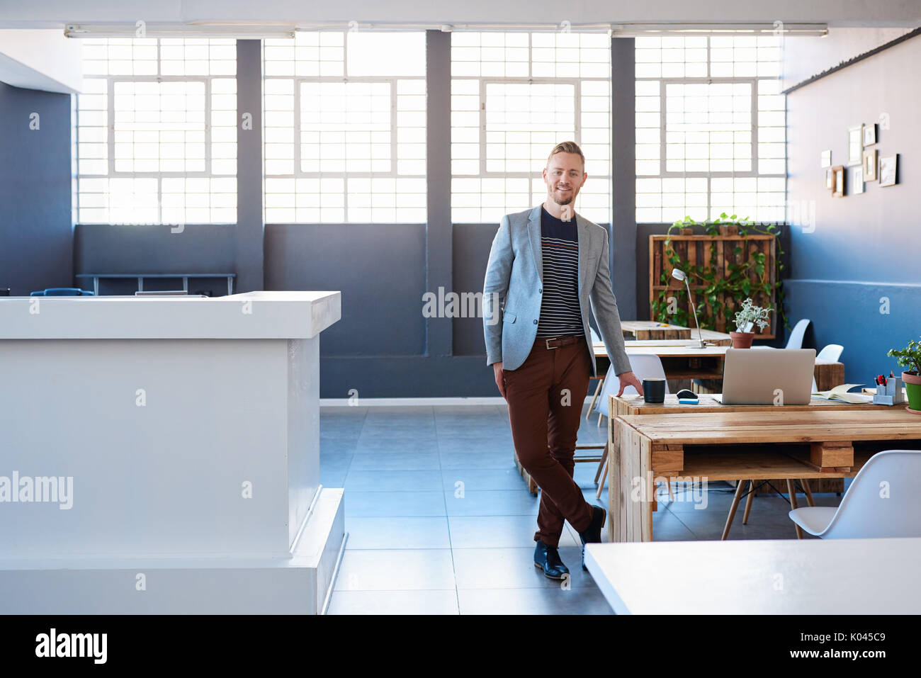 Confident young businessman standing alone in a modern office Stock ...
