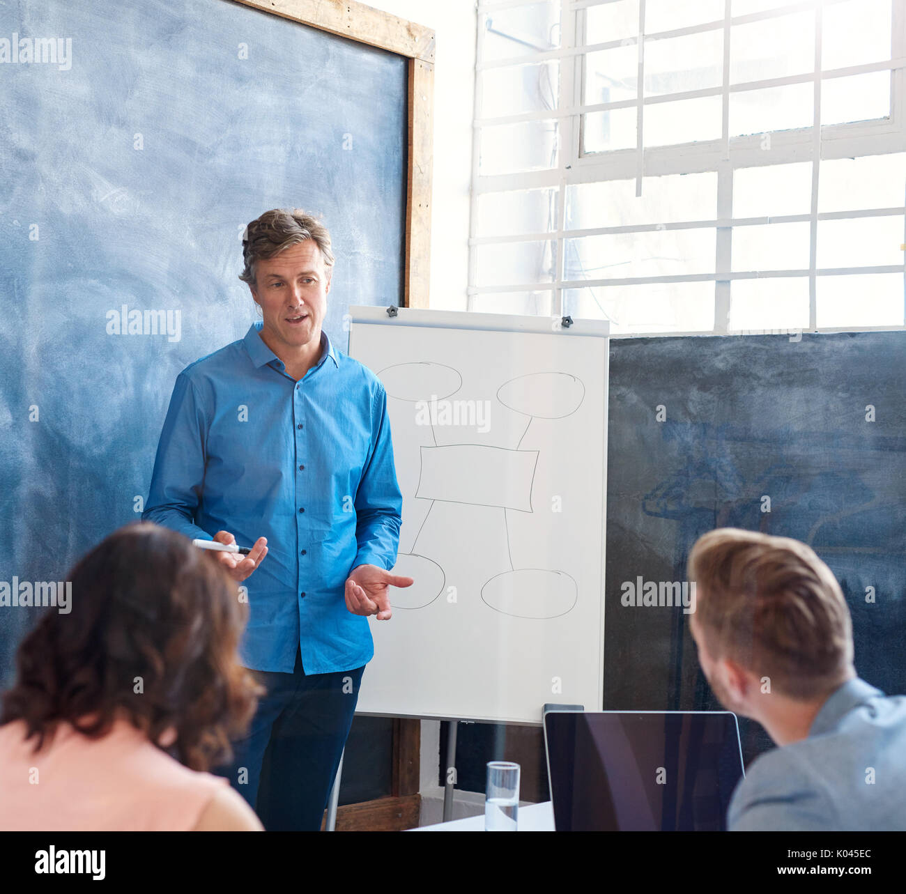 Mature manager giving a presentation to coworkers in an office Stock Photo
