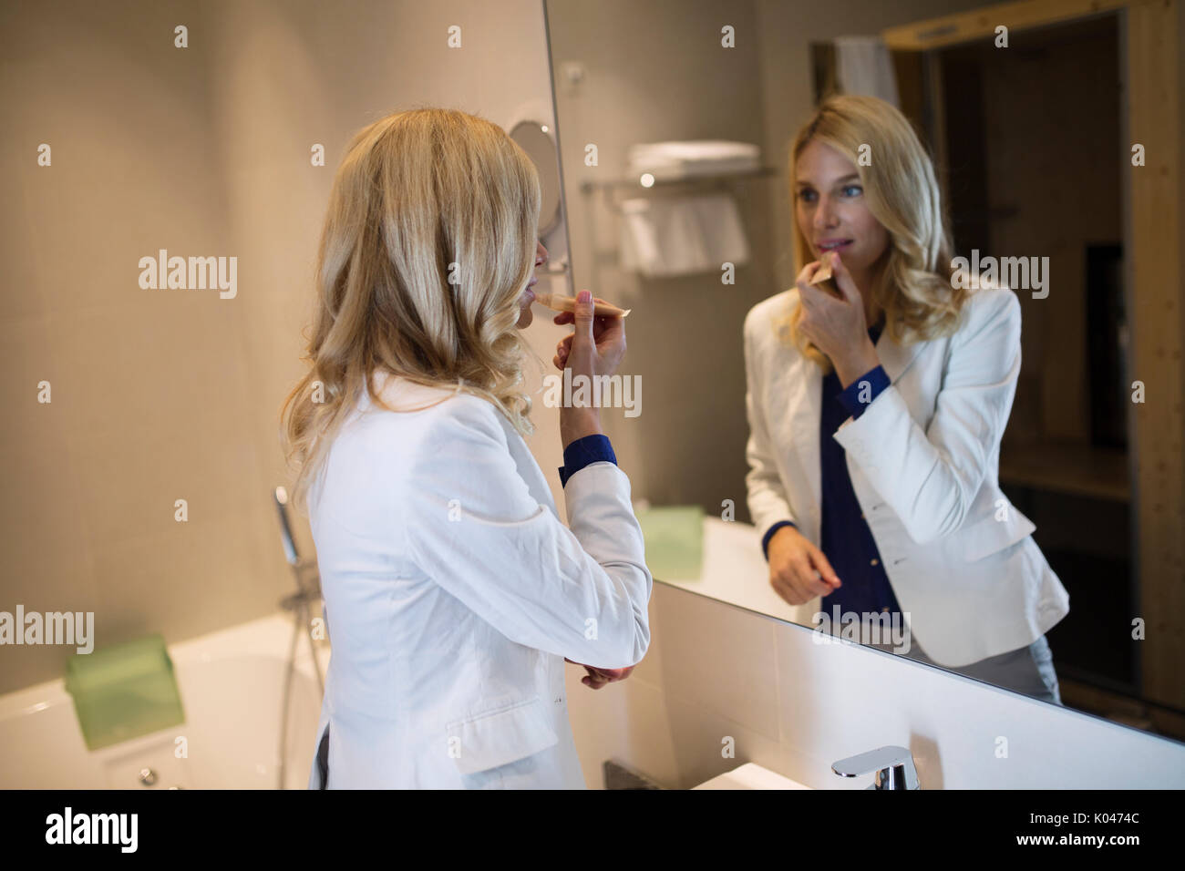 Picture of pretty businesswoman doing makeup in bathroom Stock Photo