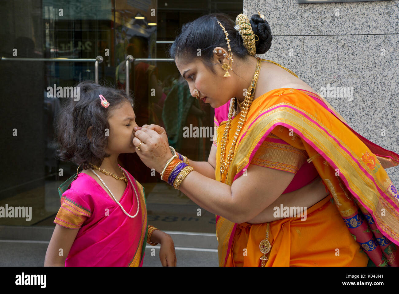 A mother adjusting her daughters nose jewelry at the start of the 2017 India Day Parade in Manhattan, New York City. Stock Photo