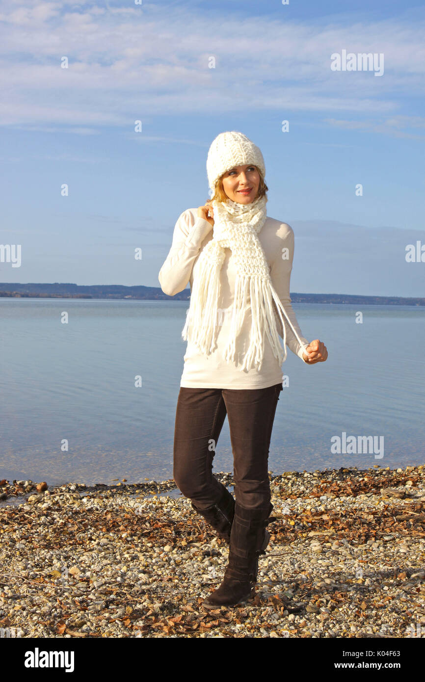 Pretty blonde middle-aged woman at a autumn walk on a lake Stock Photo