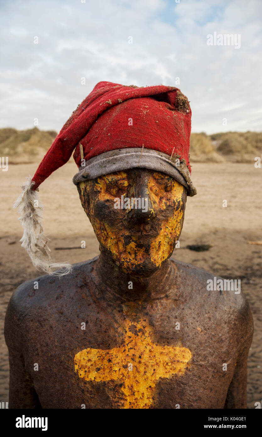 Crosby Sculpture Statue with Christmas Hat in Liverpool by Anthony Gormley Stock Photo