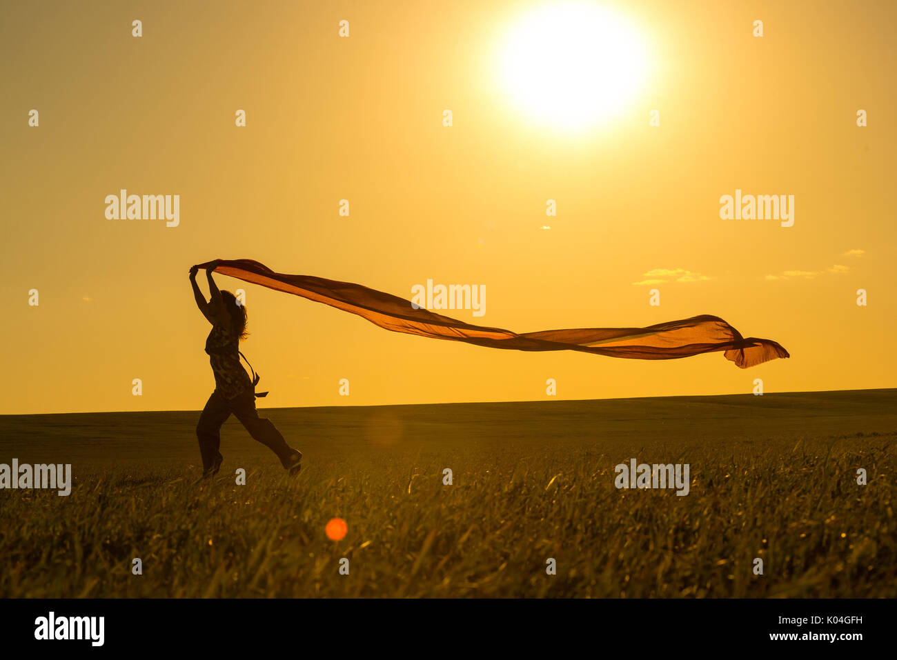 Young woman running on a rural road at sunset in summer field. Lifestyle sports freedom background Stock Photo