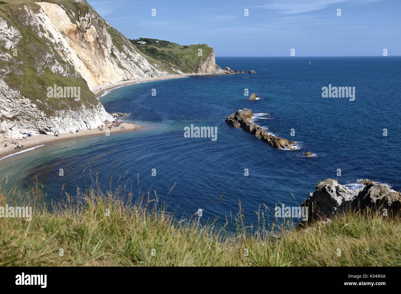 The Man o’ War rocks and St Oswald’s Bay on a warm summer’s weekend with tourists enjoying the sunshine and sea, Dorset UK Stock Photo