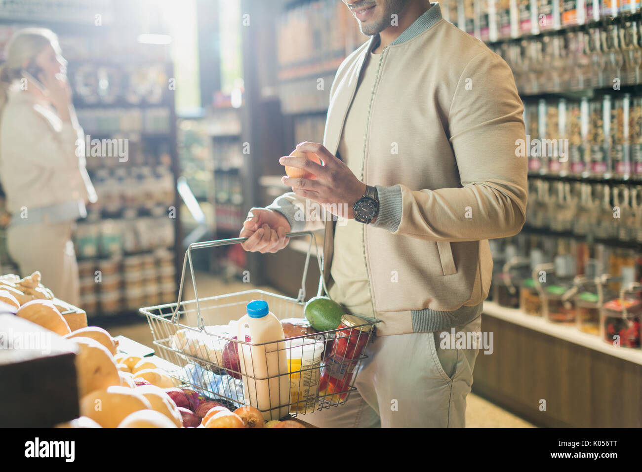 Young man grocery shopping, examining fruit in market Stock Photo