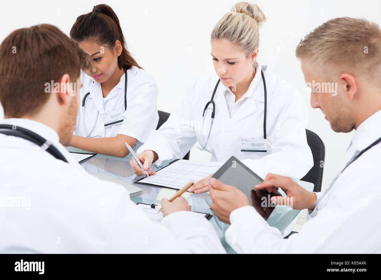 Team of doctors working at desk in clinic Stock Photo