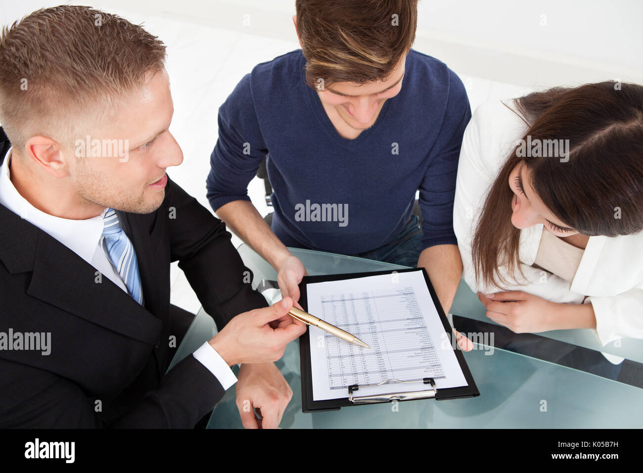 High angle view of financial advisor explaining investment plan to couple at office desk Stock Photo