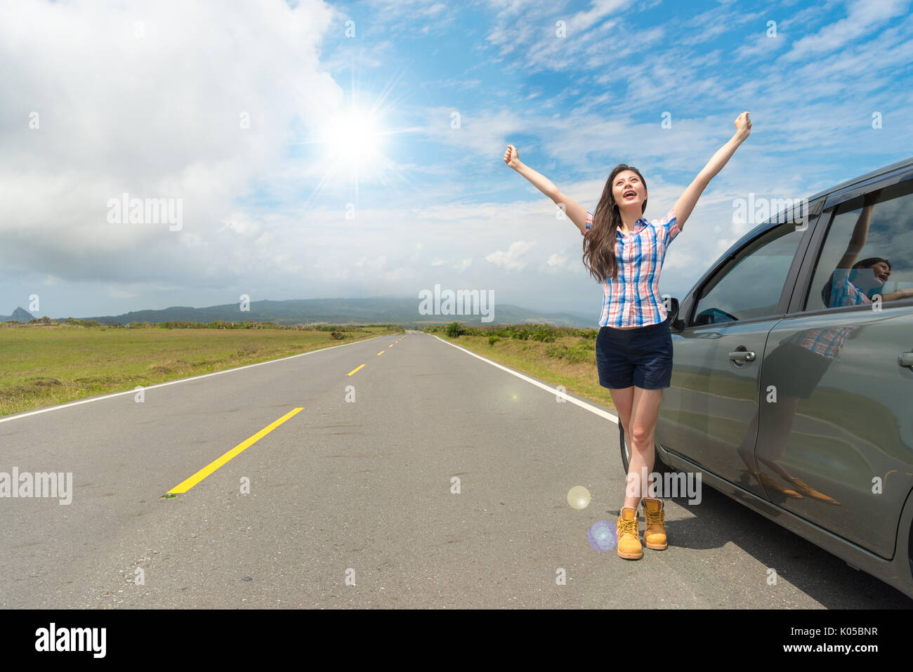 smiling beautiful woman standing on asphalt road open hands happily ...