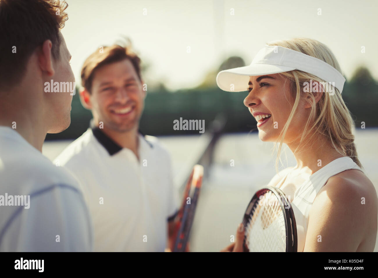 Male and female tennis players talking on tennis court Stock Photo