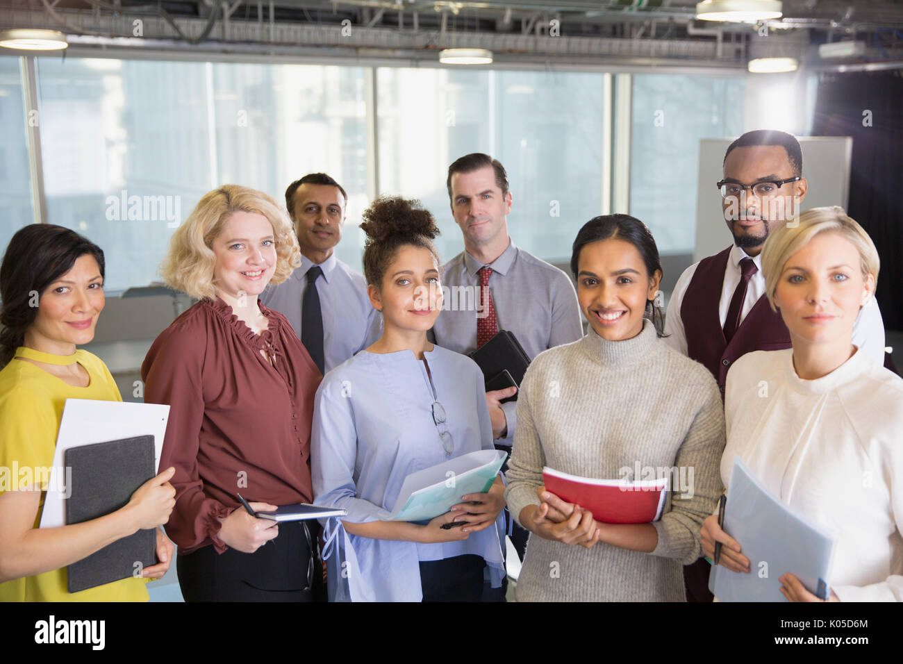 Portrait smiling business people with paperwork in conference room ...