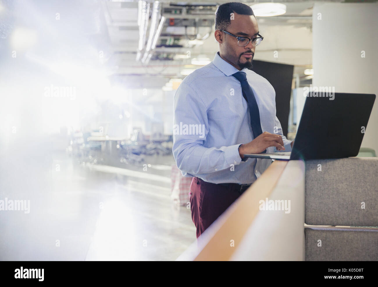 Businessman using laptop at office cubicle wall Stock Photo