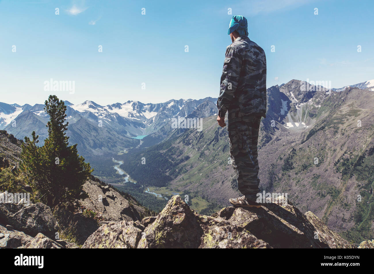 Silhouette of a man standing on the mountain top and looking into the ...