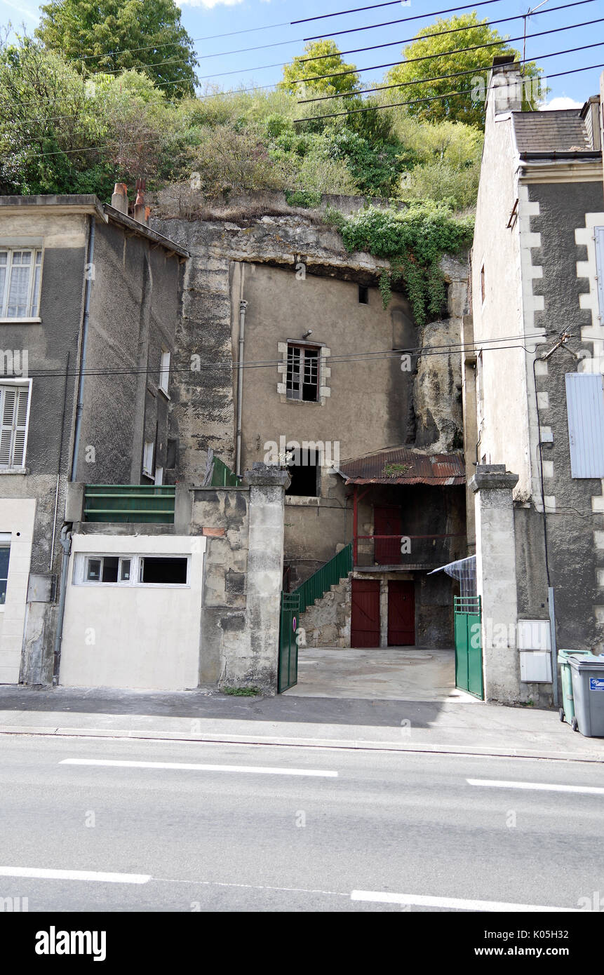 Abandoned three-storey high, light industrial premises, built into vertical limestone cliffs in Poitiers, France, possibly in earlier times a dwelling Stock Photo