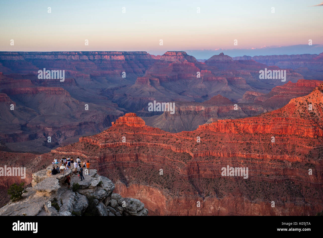 Toursits gather to take landscape photographs on the south rim of the Grand canyon in the US state of Arizona as the sun begins to set. Stock Photo