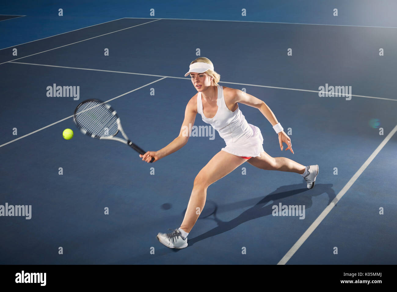 Young woman playing tennis on tennis court Stock Photo