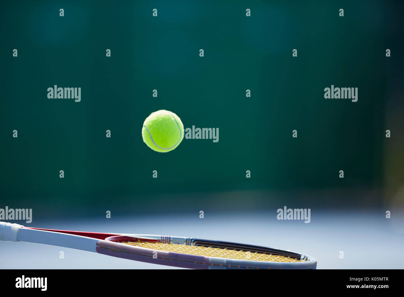 Tennis ball bouncing on tennis racket Stock Photo