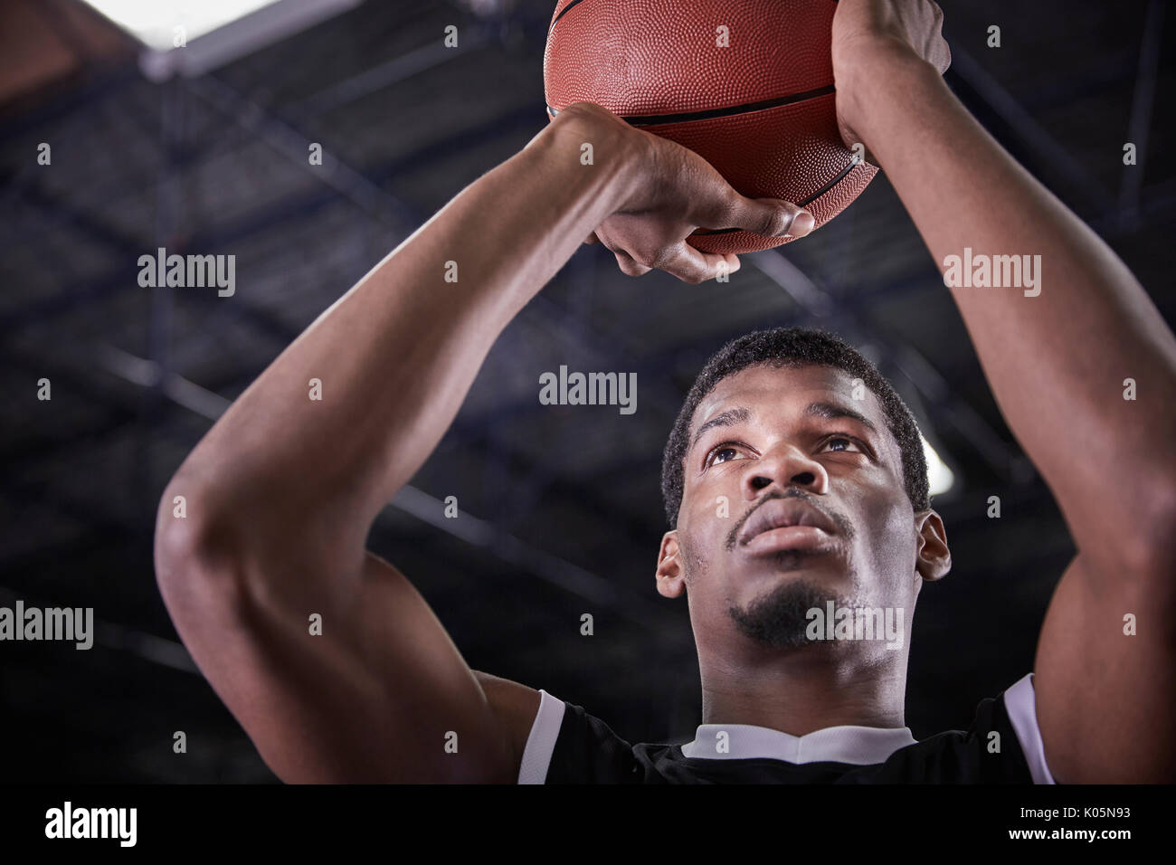 Focused young male basketball player shooting free throw Stock Photo