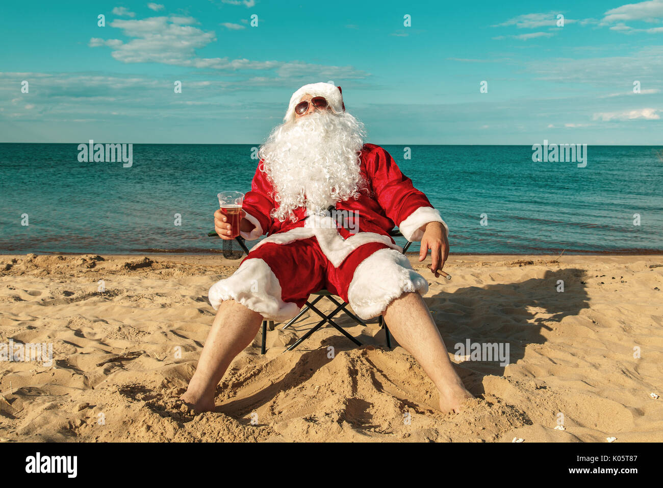 Santa Claus on the beach drinks beer and smokes a cigar Stock Photo Alamy