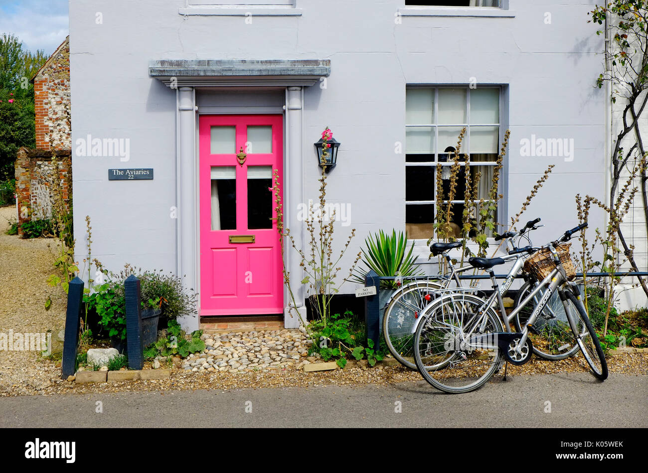 bicycles parked outside house with pink painted door, burnham market, north norfolk, england Stock Photo