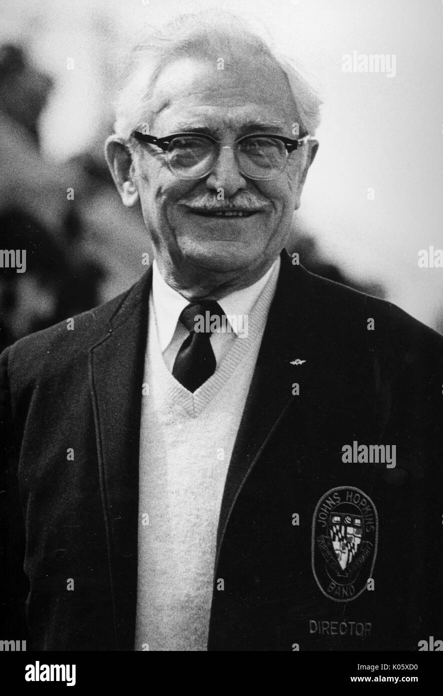 Half-length portrait of Music Director Conrad Gebelein, wearing a dark jacket with a sweater and tie underneath, has a smiling facial expression and glasses, 1960. Stock Photo