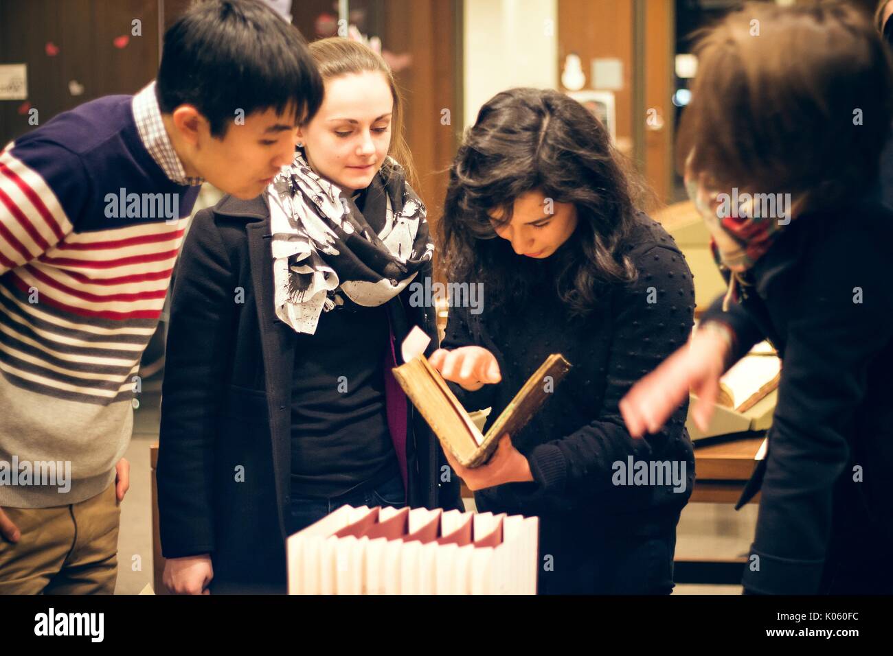 College students at the Johns Hopkins University examine books in a Special Collections library, 2016. Courtesy Eric Chen. Stock Photo