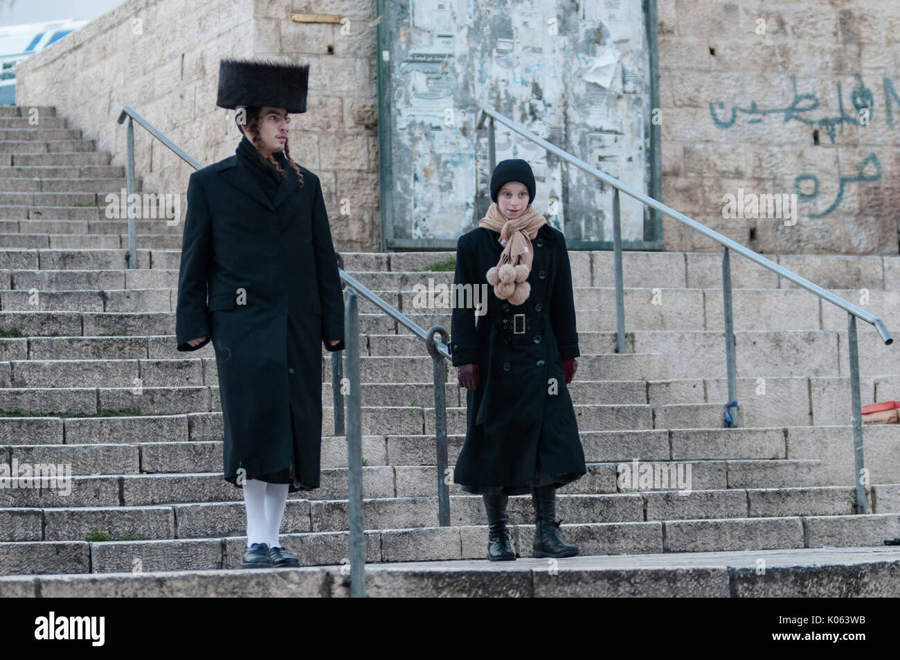 A couple of Orthodox Jews near Damascus Gate in the Old City of Jerusalem on their way to afternoon prayers on the holy day of Sabbath. Stock Photo