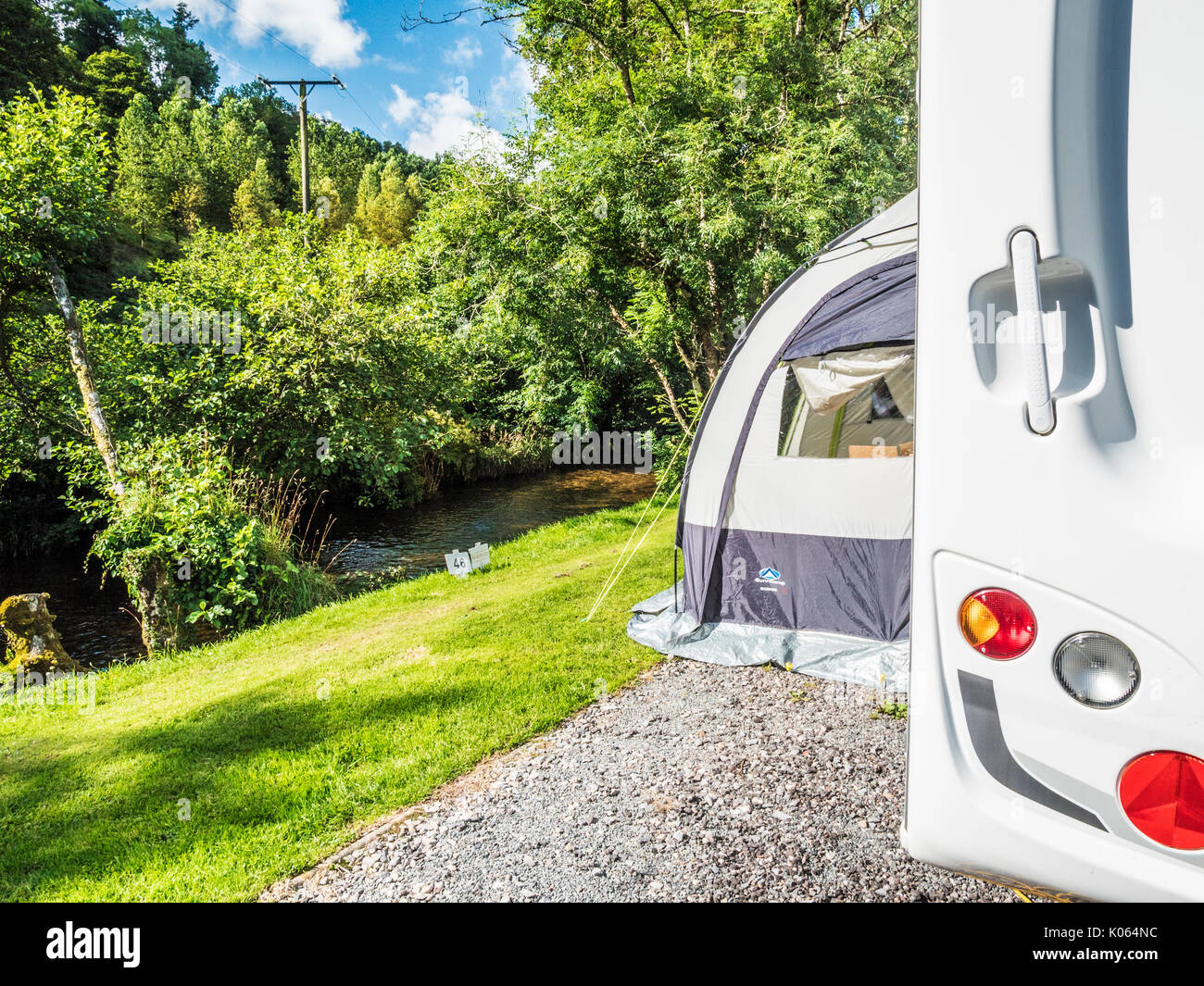 A caravan with a small porch awning pitched along the banks of the River Exe in Exmoor, Somerset. Stock Photo