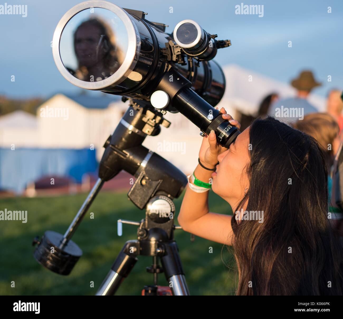 An attendee of a star party looks through a telescope at the sun the evening before the total solar eclipse August 20, 2017 in Madras, Oregon. The eclipse will be sweeping across a narrow portion of the contiguous United States from Lincoln Beach, Oregon to Charleston, South Carolina on August 21, 2017. Stock Photo
