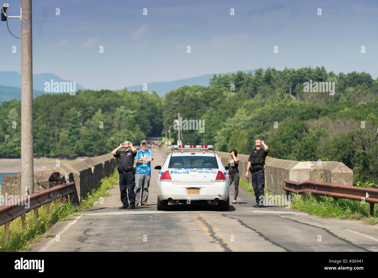 Olivebridge, NY, USA 21st August, 2017 - Two Department Of Environmental Protection Officers look at the solar eclipse with borrowed solar glasses from local residents. Credit: Sinisa Kukic/Alamy Live News Stock Photo
