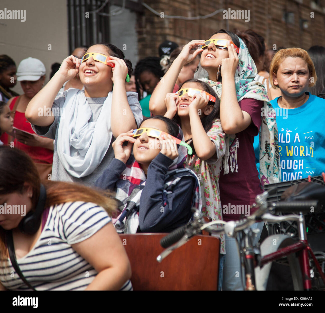 Crowd observes a solar eclipse safely through protective glasses ...