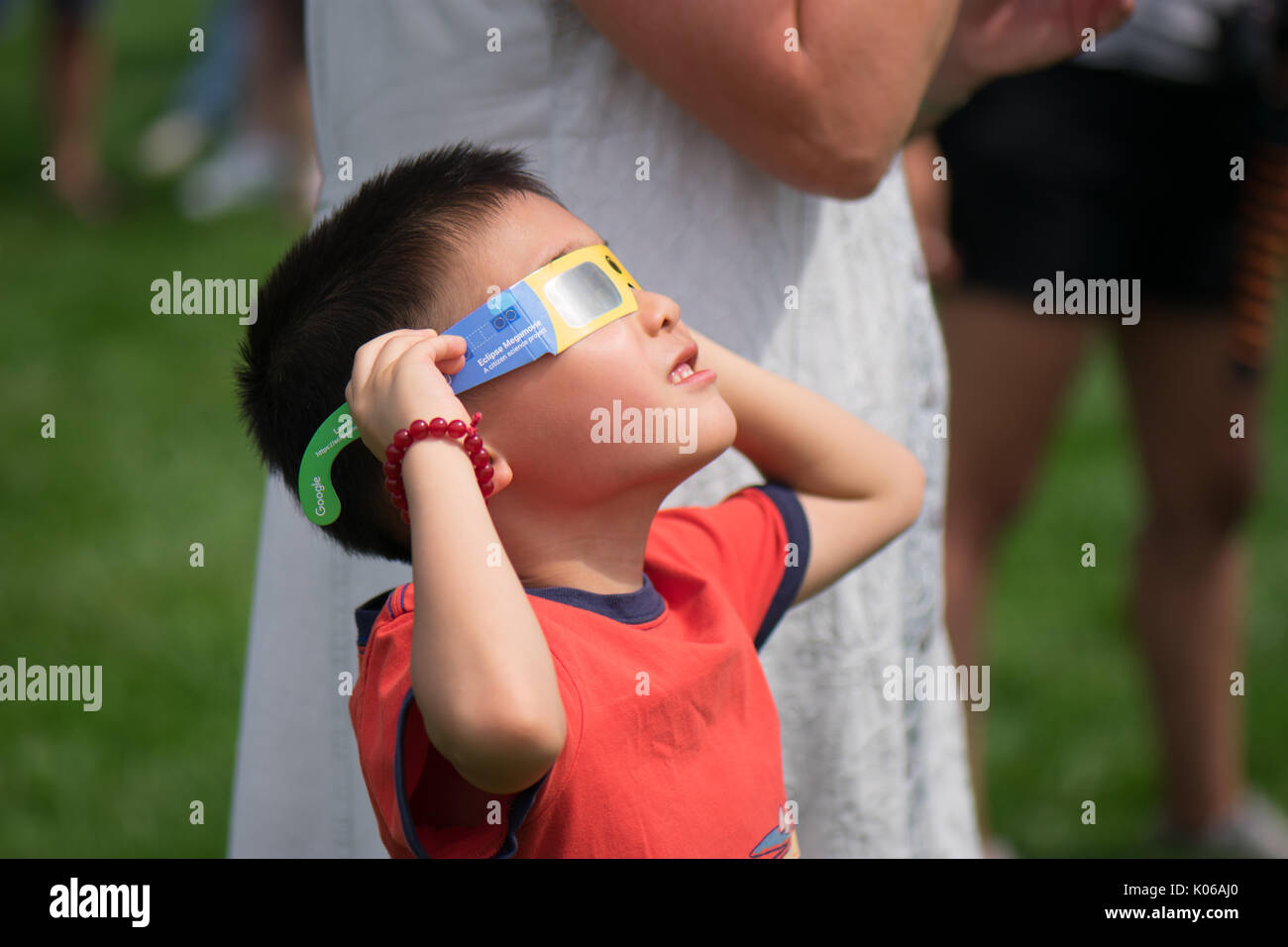Amherst, USA. 21st Aug, 2017. Asian American boy watching eclipse with special glasses. Credit: Edgar Izzy/Alamy Live News Stock Photo
