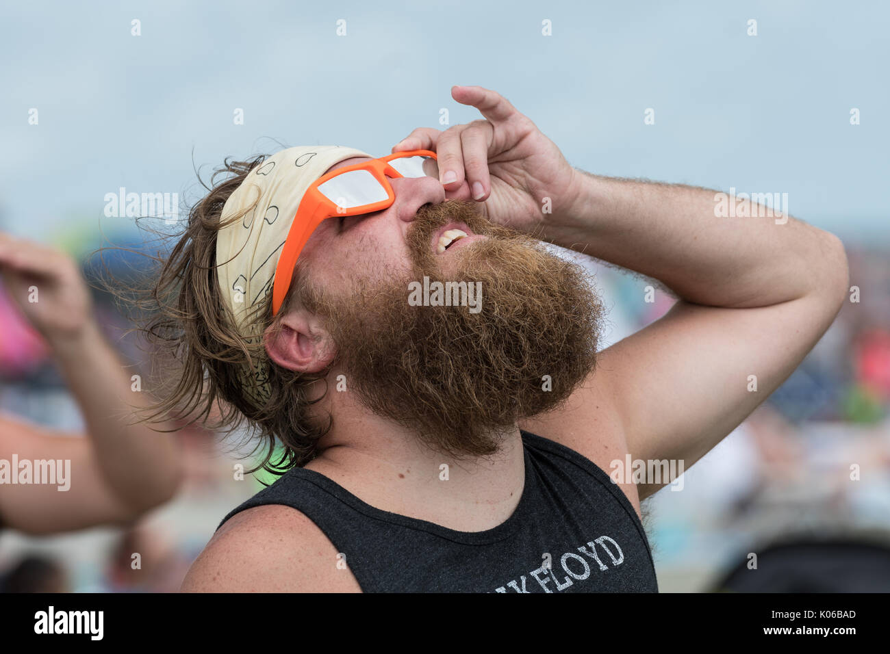 Charleston, Isle of Palms, USA. 21st Aug, 2017. A beach goer looks up at the total solar eclipse over the beach outside Charleston August 21, 2017 in Isle of Palms, South Carolina. The solar eclipse after sweeping across the nation crosses the Charleston area before heading over the Atlantic Ocean. Credit: Planetpix/Alamy Live News Stock Photo