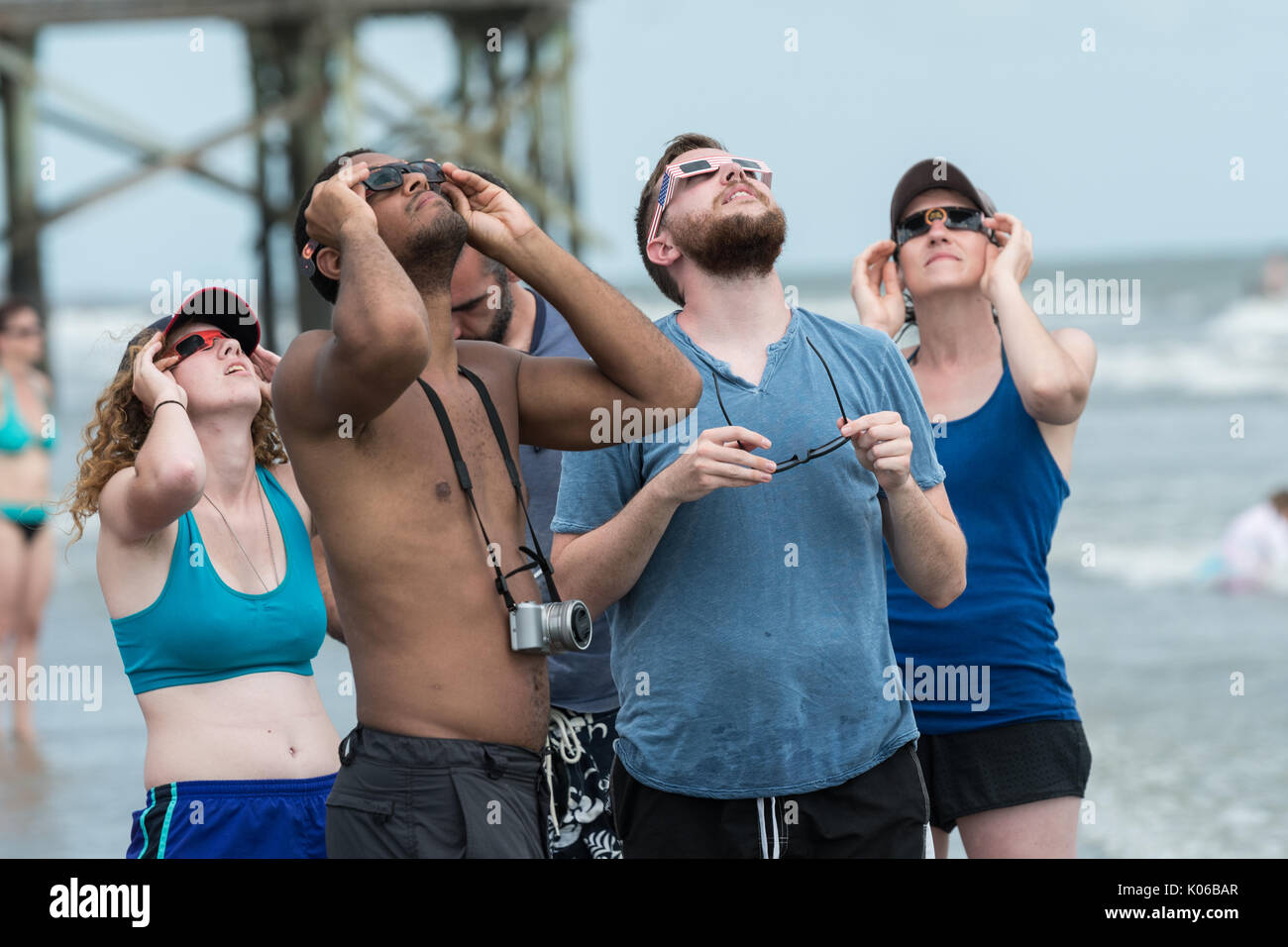 Charleston, Isle of Palms, USA. 21st Aug, 2017. A group of people view the total solar eclipse as it passes over the beach outside Charleston August 21, 2017 in Isle of Palms, South Carolina. The solar eclipse after sweeping across the nation crosses the Charleston area before heading over the Atlantic Ocean. Credit: Planetpix/Alamy Live News Stock Photo