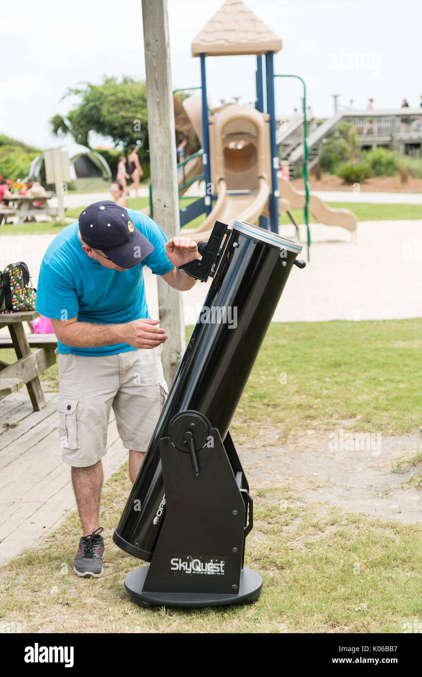 Charleston, Isle of Palms, USA. 21st Aug, 2017. A man checks the settings on his telescope in preparation for the total solar eclipse as thousands gather on the beach outside Charleston August 21, 2017 in Isle of Palms, South Carolina. The solar eclipse after sweeping across the nation crosses the Charleston area before heading over the Atlantic Ocean. Credit: Planetpix/Alamy Live News Stock Photo
