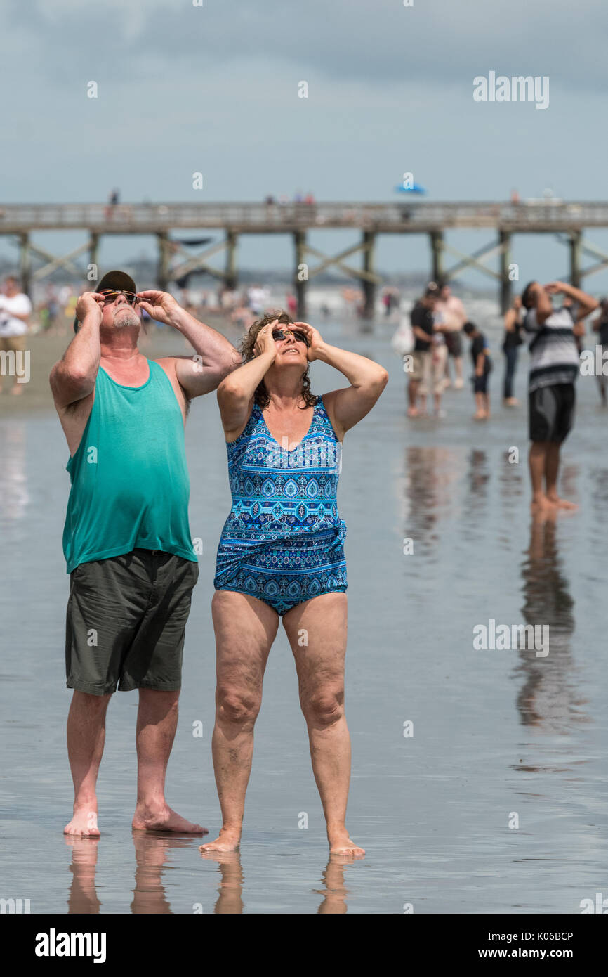 Charleston, Isle of Palms, USA. 21st Aug, 2017. People watch the total solar eclipse standing along the shore as it passes over the beach outside Charleston August 21, 2017 in Isle of Palms, South Carolina. The solar eclipse after sweeping across the nation crosses the Charleston area before heading over the Atlantic Ocean. Credit: Planetpix/Alamy Live News Stock Photo
