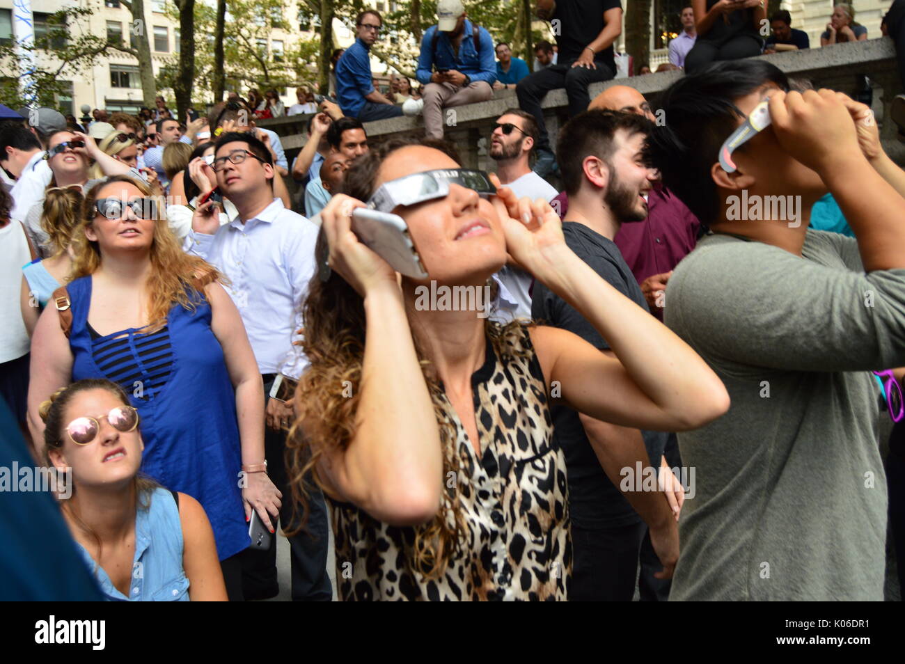 New Yorkers don their solar glasses to view the solar eclipse in Bryant Park in Manhattan Stock Photo