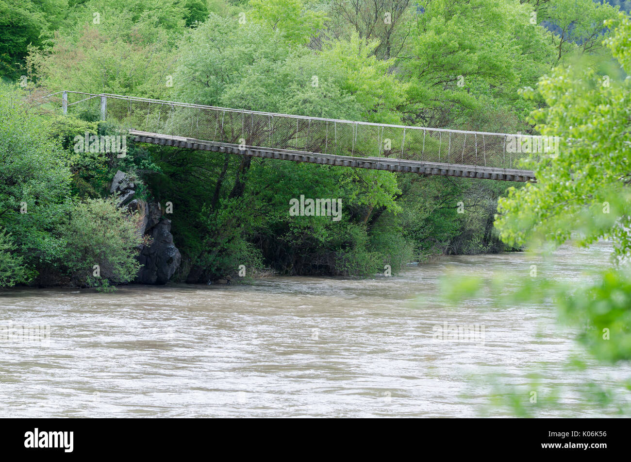 Old wooden bridge over flood mountain river in Georgia. Stock Photo