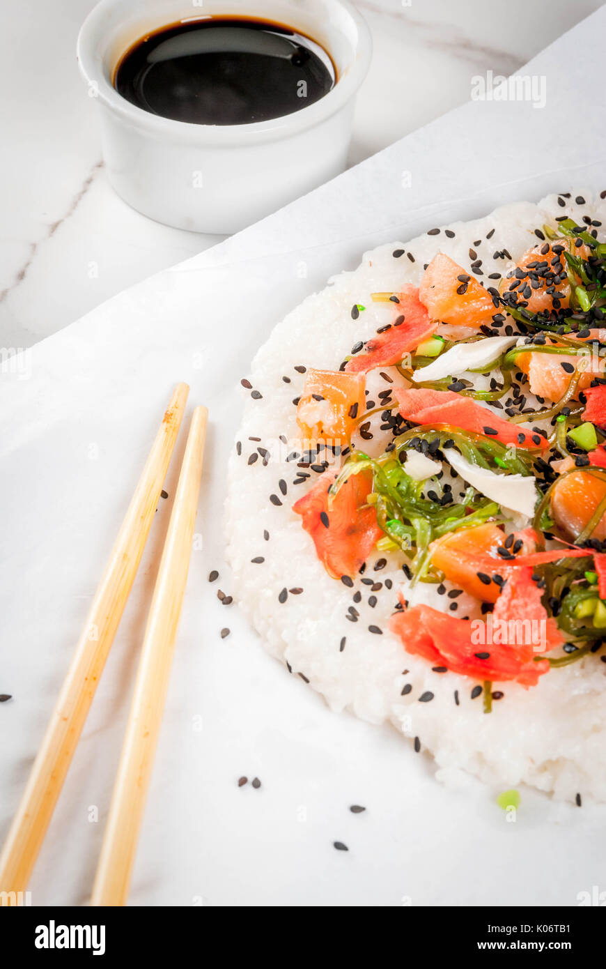Trend hybrid food. Japanese, Asian cuisine. Sushi pizza with salmon, hayashi wakame, daikon