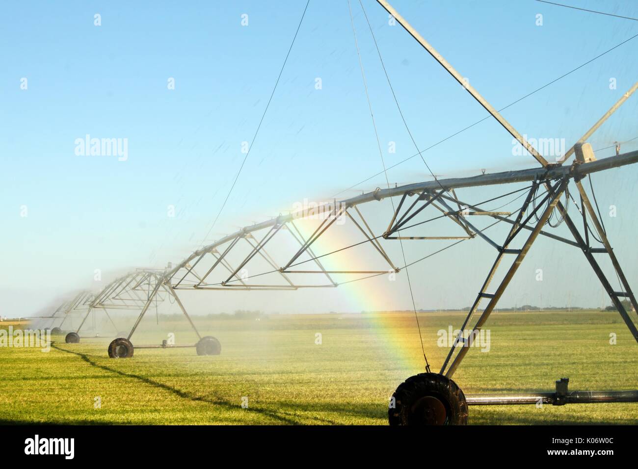 Irrigation spraying system making rainbow in field Stock Photo