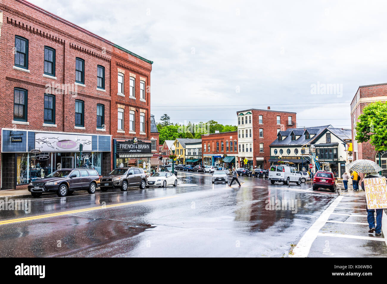 Camden, USA - June 9, 2017: Downtown small village in Maine during rain with person walking carrying roller derby sign Stock Photo