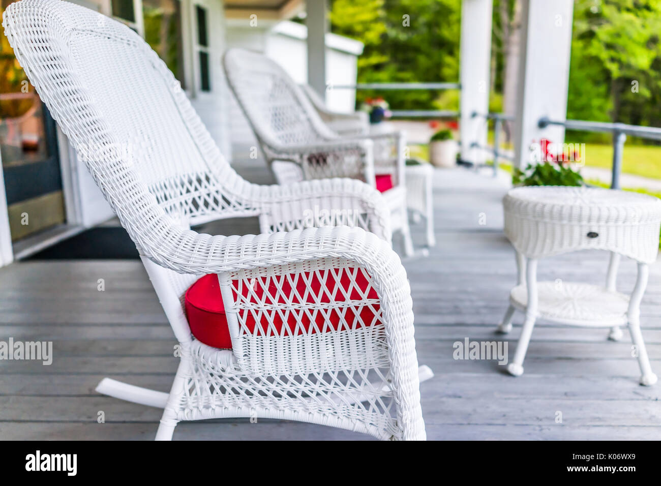 Front porch of house with white rocking chairs on wooden deck Stock Photo