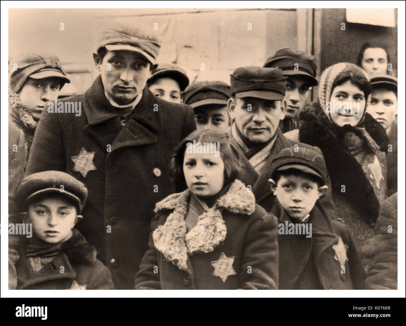 LODZ JEWISH GHETTO Men Women and Children stare at the Nazi photographers camera in apprehension, wearing Nazi designated 'Star of David' yellow stars to denote Jewish people, in the infamous Polish Lodz Ghetto Poland. Most were taken to Nazi concentration camps to fulfil Hitler's 'final solution'. Facilitated by the infamous war criminal Heinrich Himmler. Stock Photo