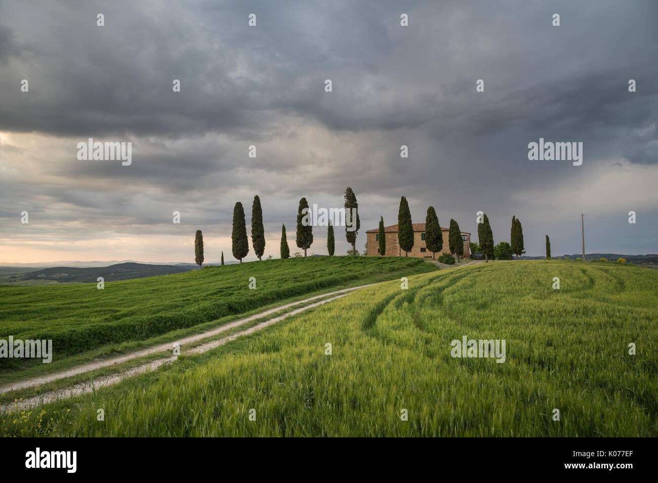 San Quirico d'Orcia, Tuscany, Italy. A farmhouse at sunset, during a stormy day. Stock Photo