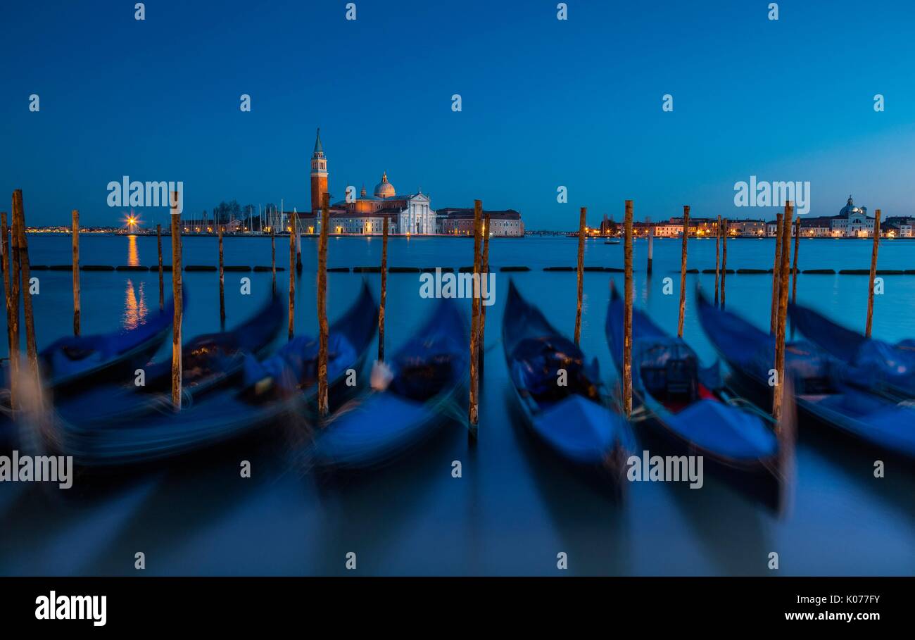 Venice, Veneto, Italy. View of San Giorgio cathedral during a quiet winter evening, with gondolas on the foreground. Stock Photo
