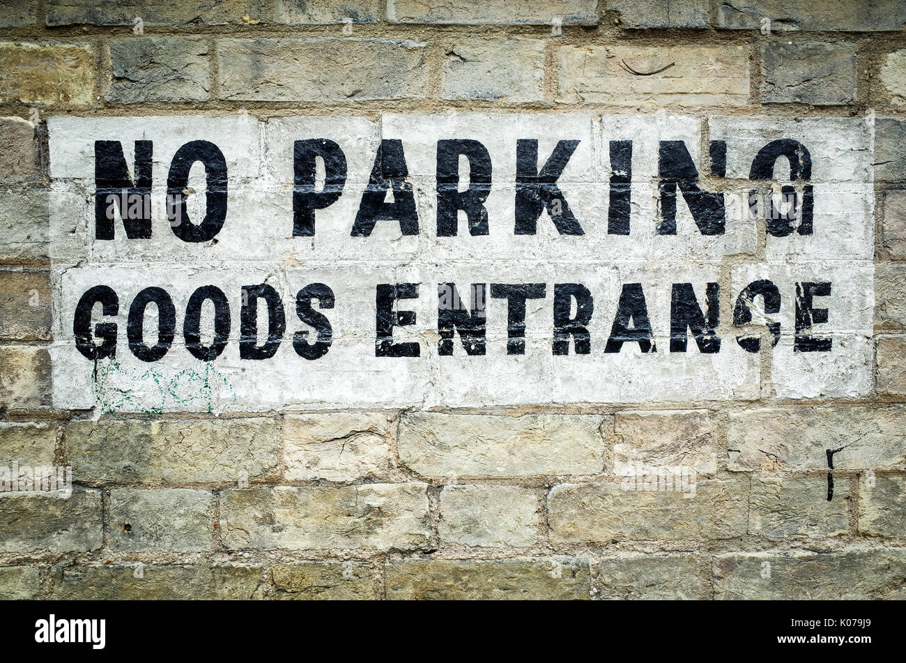 No Parking Goods Entrance Sign on a brick wall Stock Photo