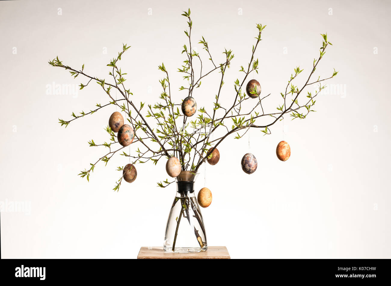 Vase with tree branches and multicolored hand painted easter eggs Stock Photo
