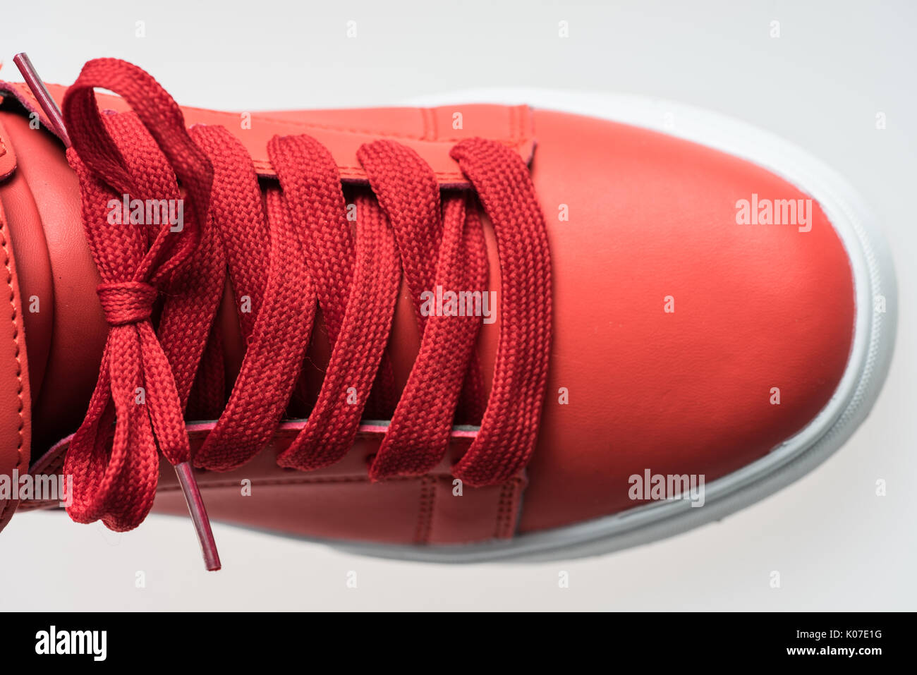 Fashion shoes with shoestring. Red sneaker and shoelace isolated on white background Stock Photo