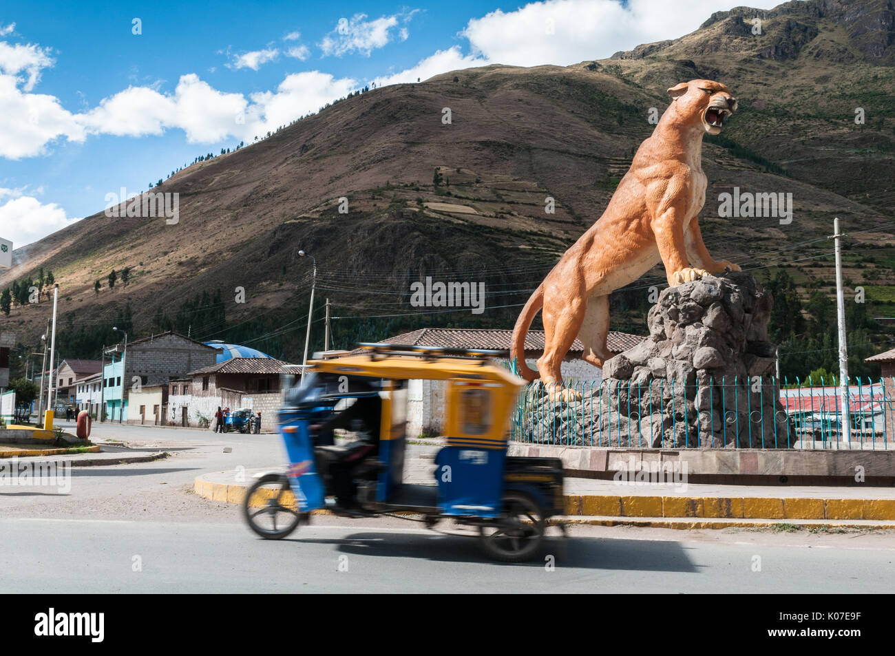 Mototaxi, a popular form of transport in Peru by the statue of puma in a village of Calca near Cusco. Stock Photo