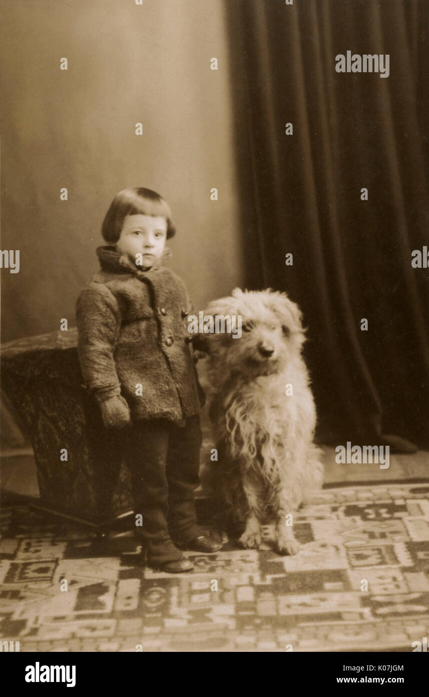 Little boy in his winter woollies and the family pet dog Stock Photo